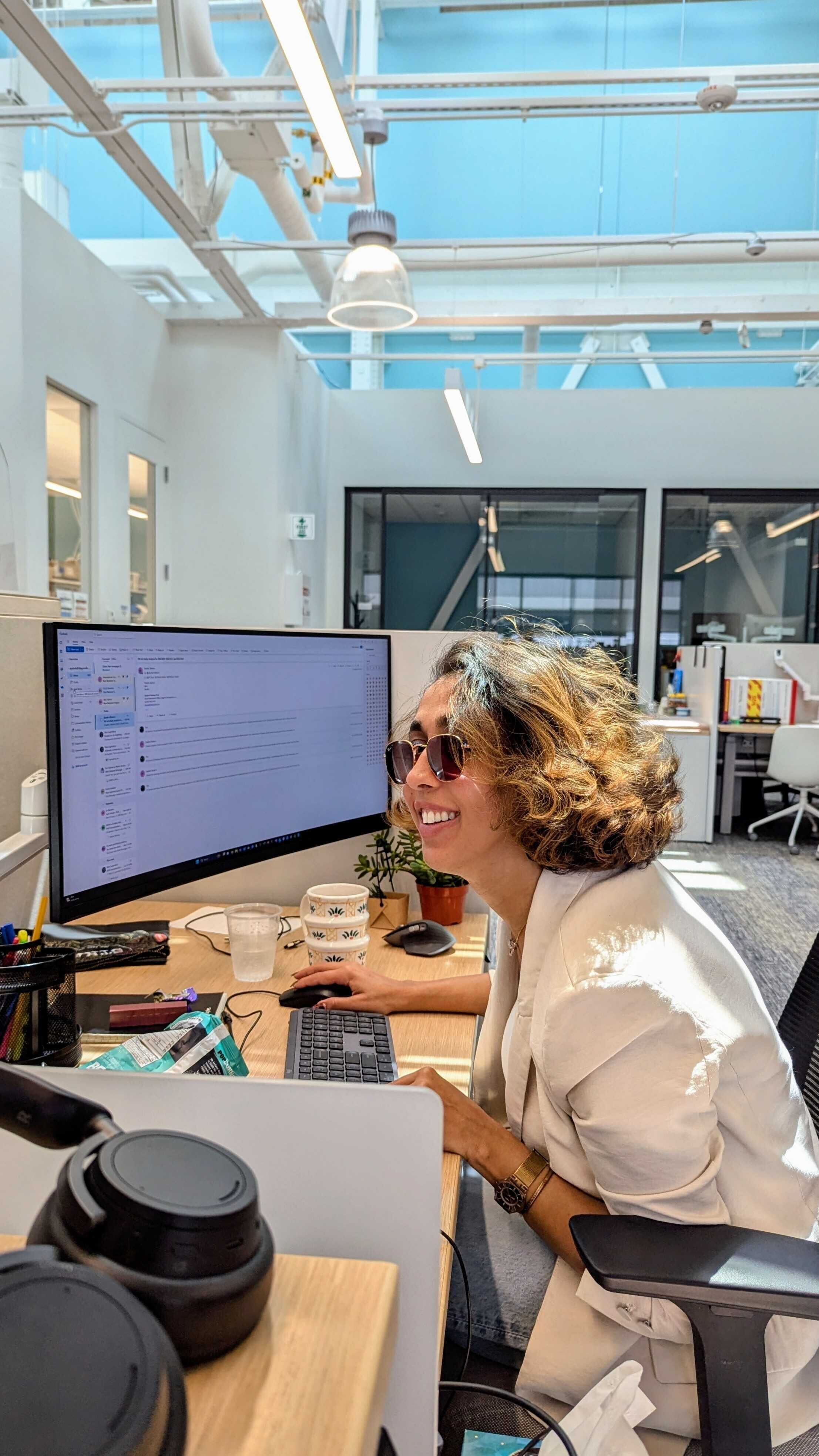 Aysheh Alrfooh smiling at her desk
