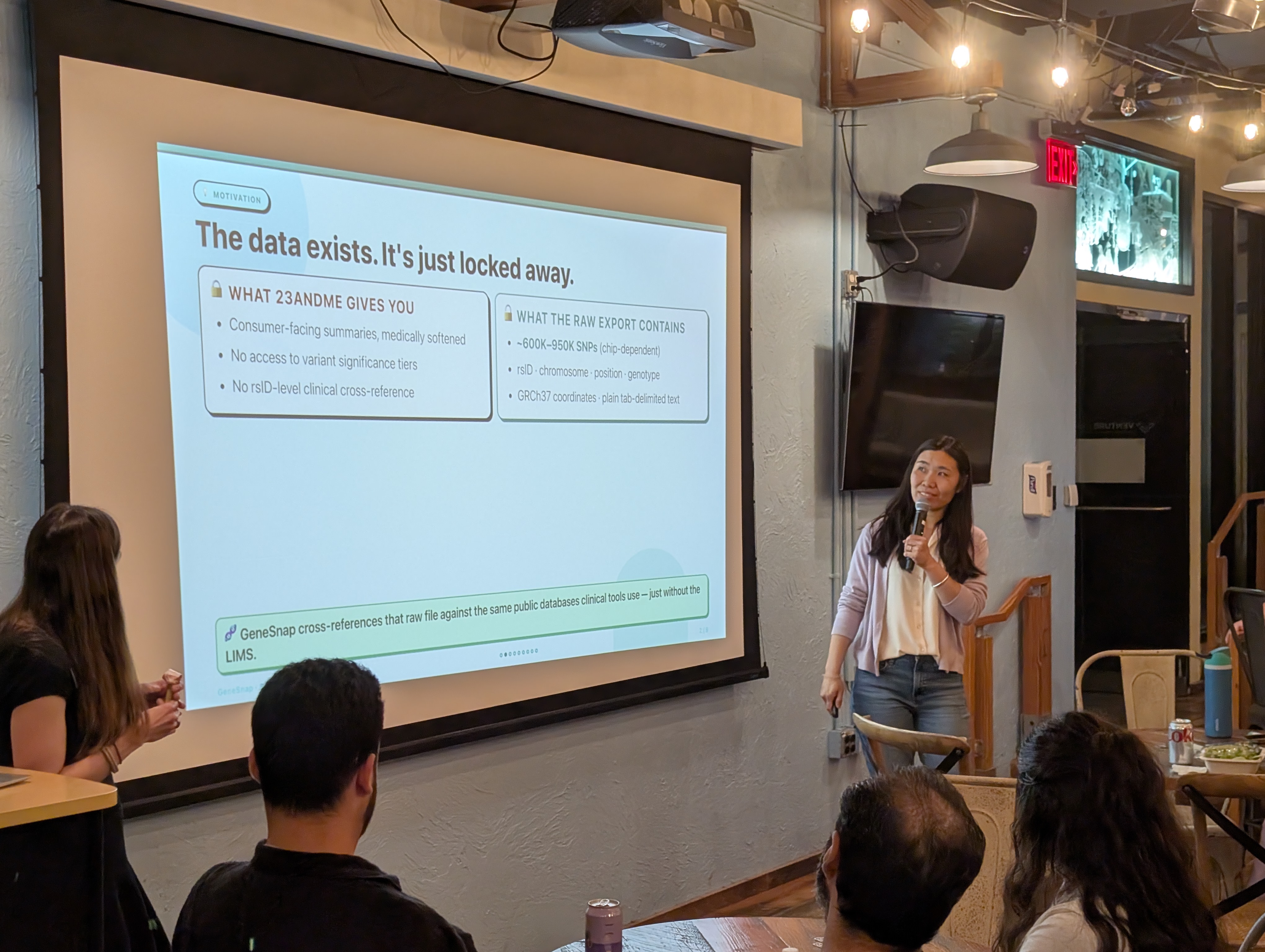 Sen Yao presents a slide titled "the data exists. it's just locked away". The slide features a side-by-side comparison of two boxes: one illustrating the standard results returned by 23andMe, and the other showing the extensive data contained within a raw file export.